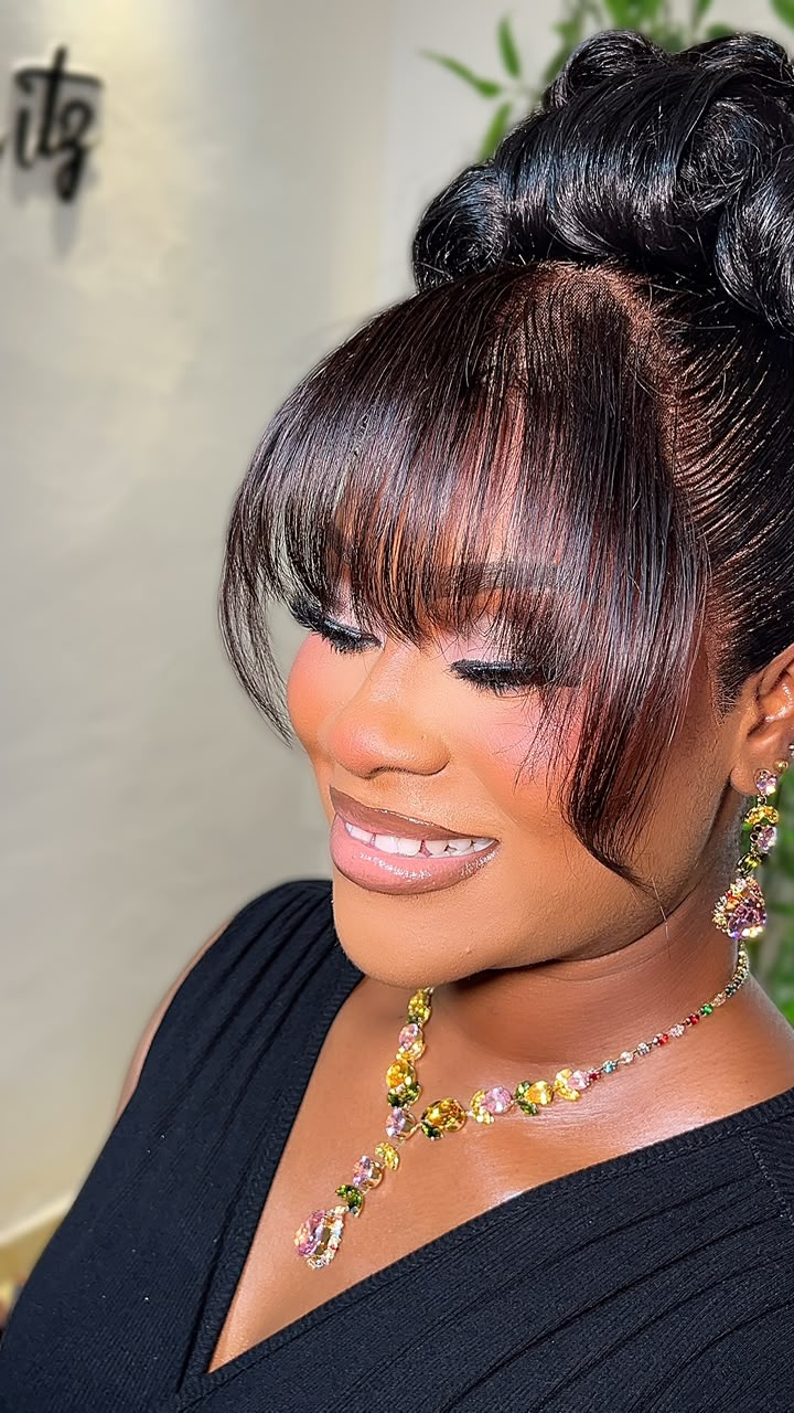Sculpted black updo with sleek auburn fringe and face-framing layers
